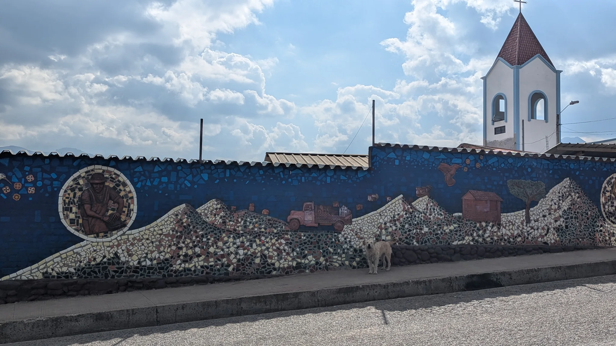 Un mural con una iglesia y figuras decorativas se extiende por un muro.