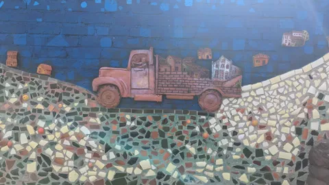 Un mural de un camión cubre un muro texturizado.