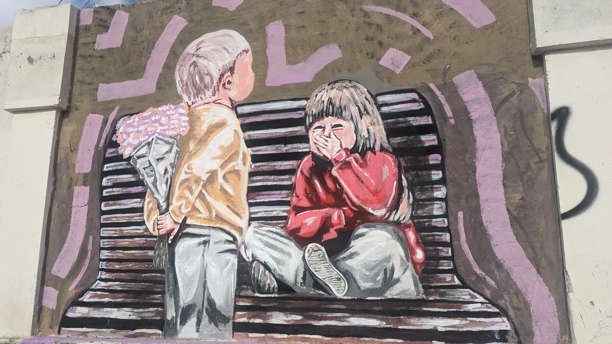 Un mural muestra dos figuras sentadas y escalones estilizados.