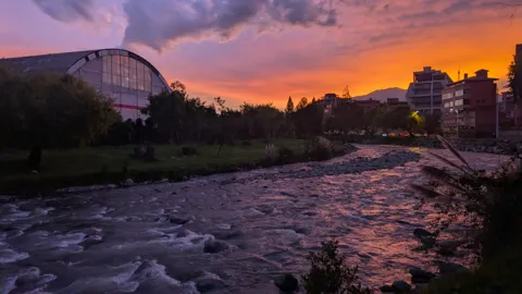 Un puente y un río bajo un cielo violeta