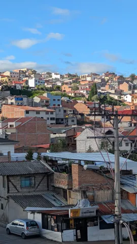 Los tejados de un barrio de Cuenca se apilan sobre una ladera bajo un cielo despejado.
