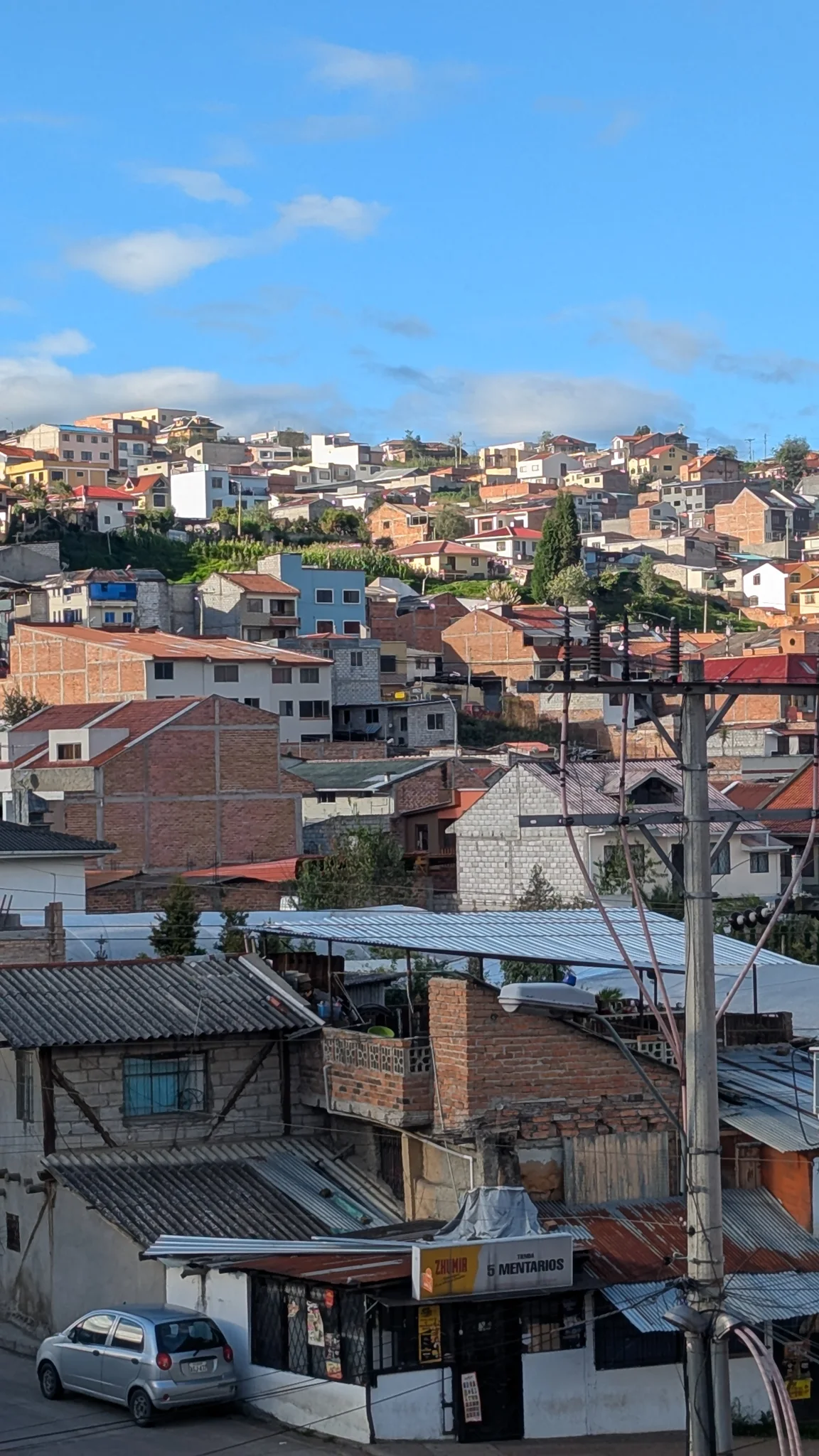 Los tejados de un barrio de Cuenca se apilan sobre una ladera bajo un cielo despejado.