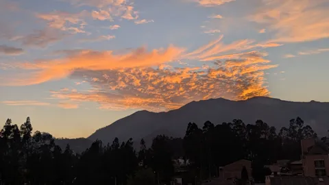 Nubes anaranjadas sobre siluetas de montaña