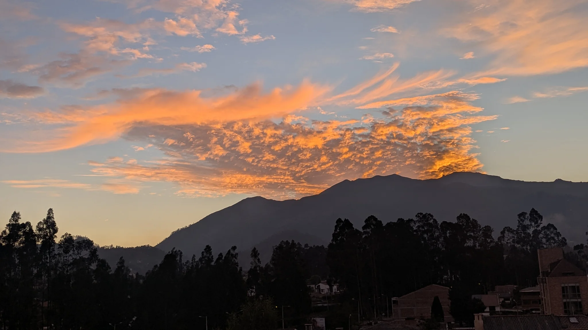 Nubes anaranjadas sobre siluetas de montaña