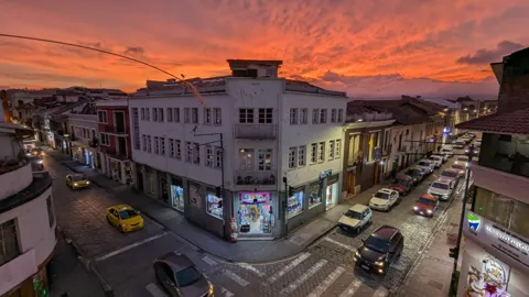 Una esquina de la ciudad bajo un cielo anaranjado