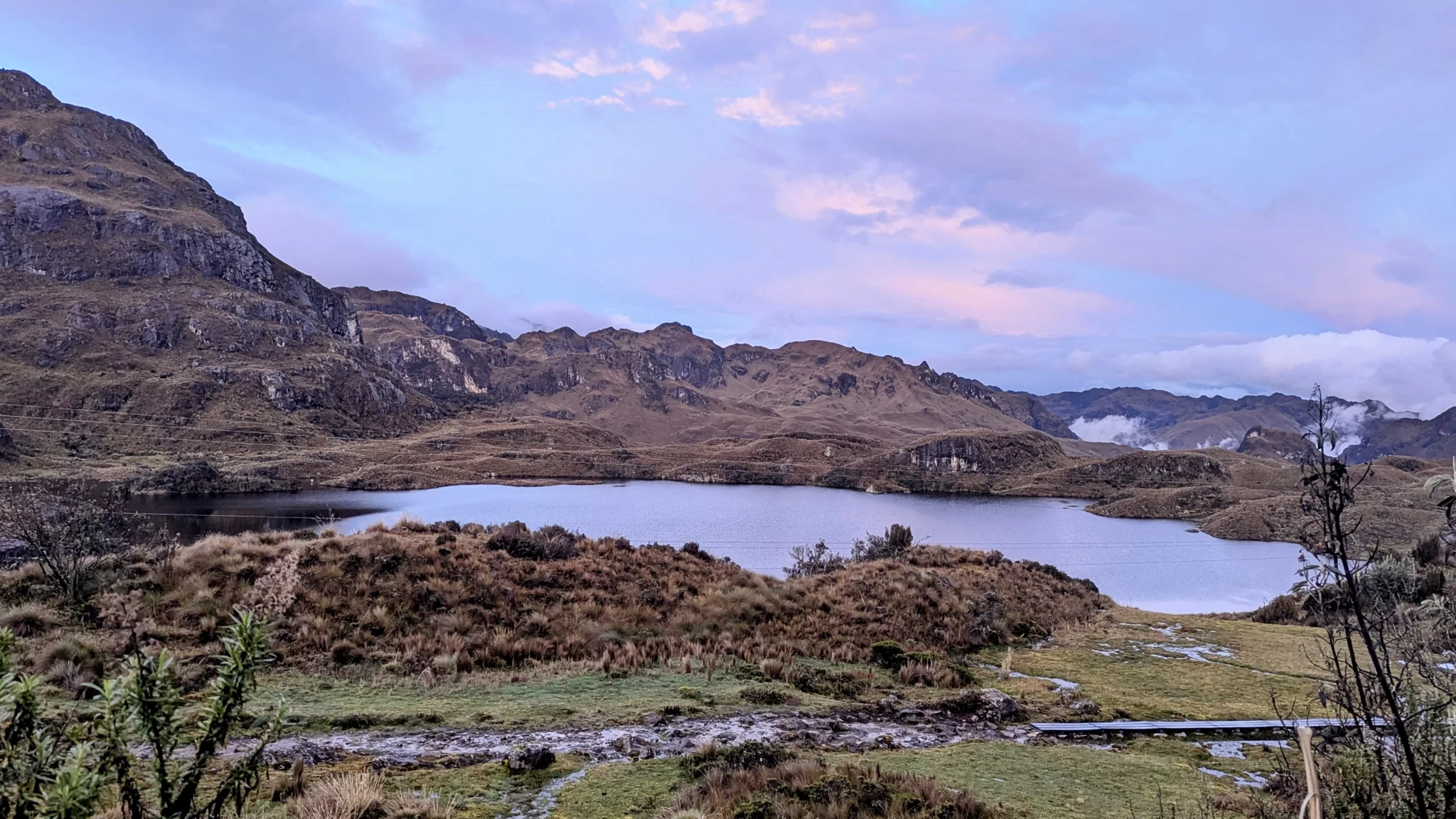 La orilla de una laguna al caer la tarde
