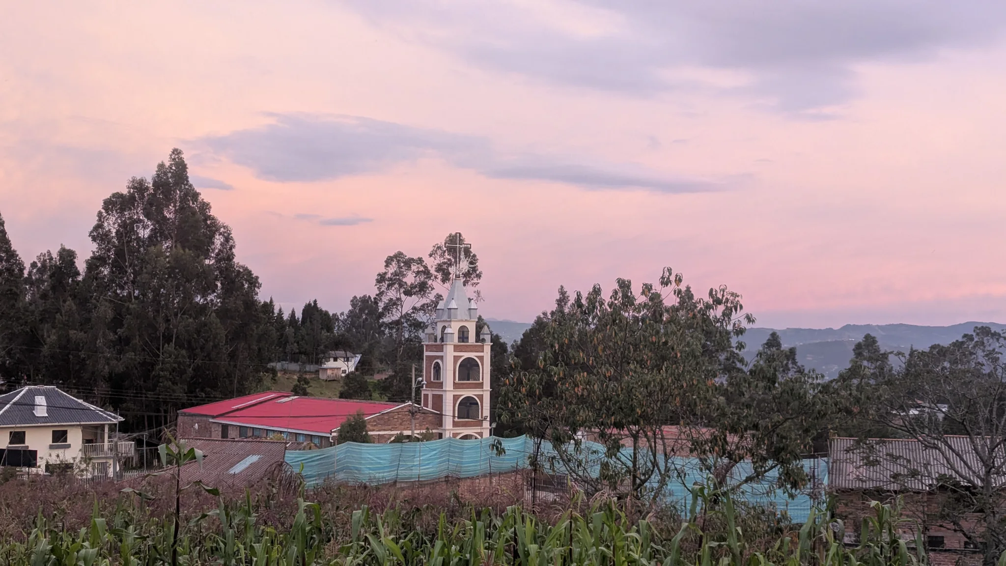 Una torre de iglesia bajo nubes rosadas