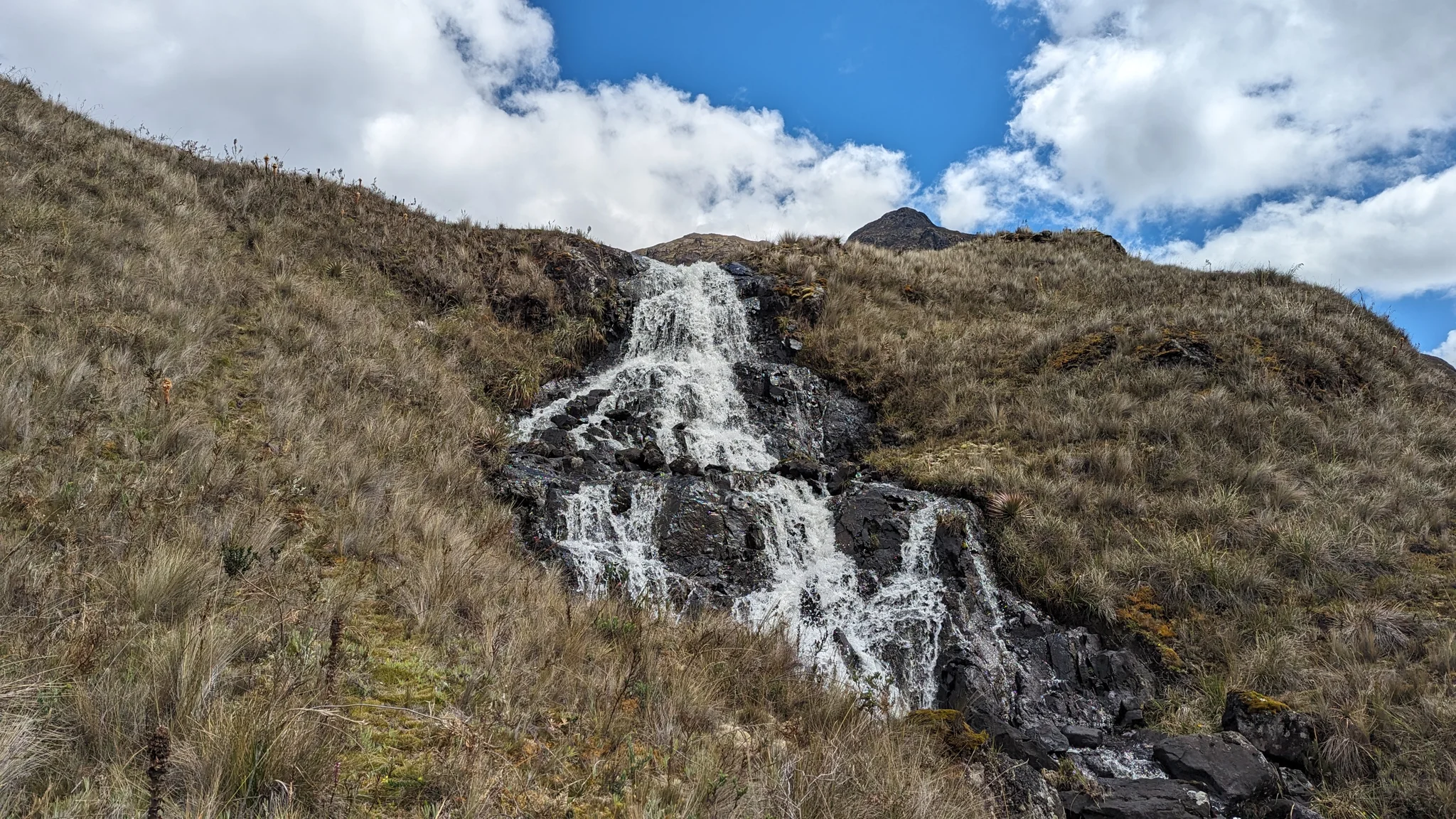 Una cascada que cruza una ladera abierta