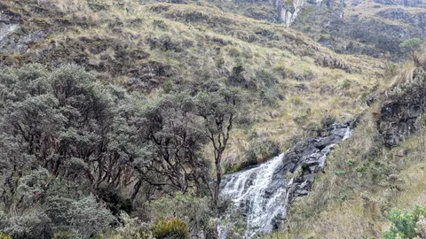 Agua blanca al pie de una ladera rocosa
