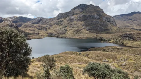 Una laguna bajo picos rocosos. El nombre del cuerpo de agua sigue sin confirmarse.