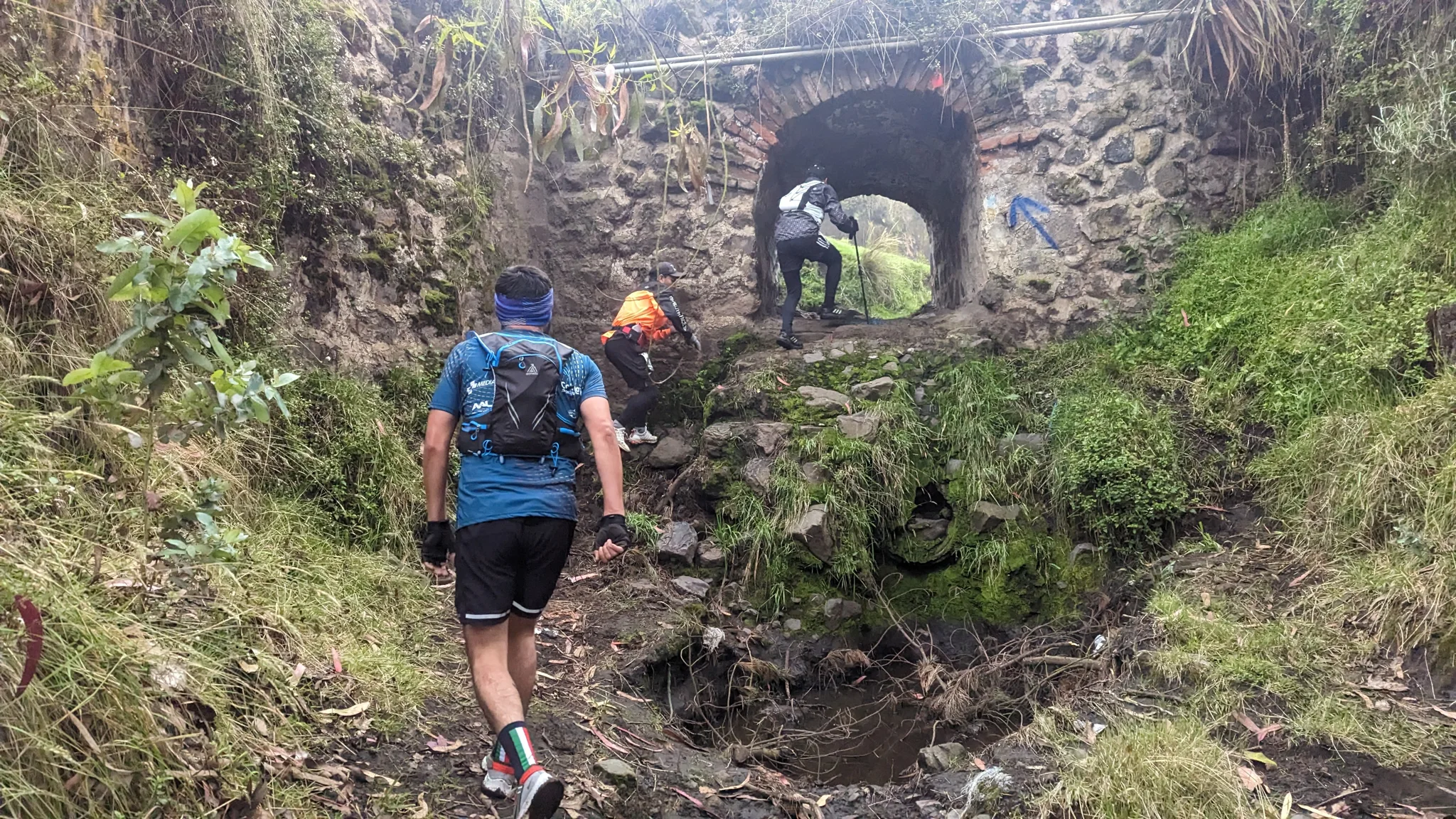 Un acceso lodoso a un arco de piedra