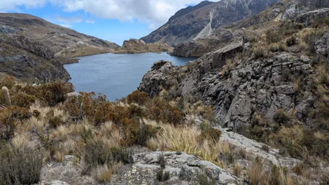 Una laguna azul tras una orilla rocosa. El nombre del cuerpo de agua sigue sin confirmarse.
