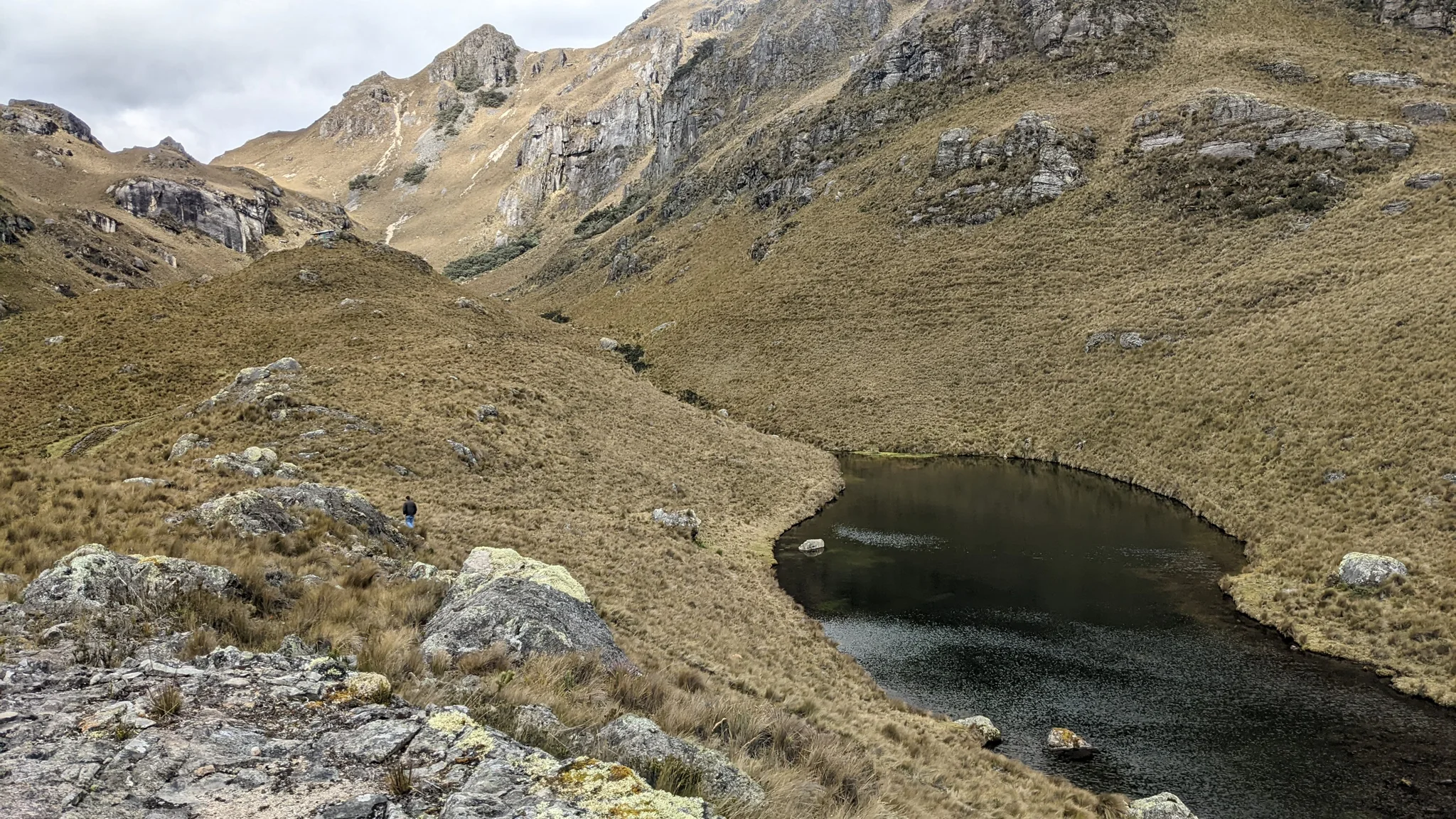 Una laguna redondeada bajo cumbres. El nombre del cuerpo de agua sigue sin confirmarse.