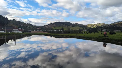 Una laguna refleja las nubes. El nombre del cuerpo de agua sigue sin confirmarse.