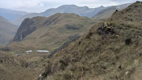 Una laguna pequeña bajo una cresta. El nombre del cuerpo de agua sigue sin confirmarse.