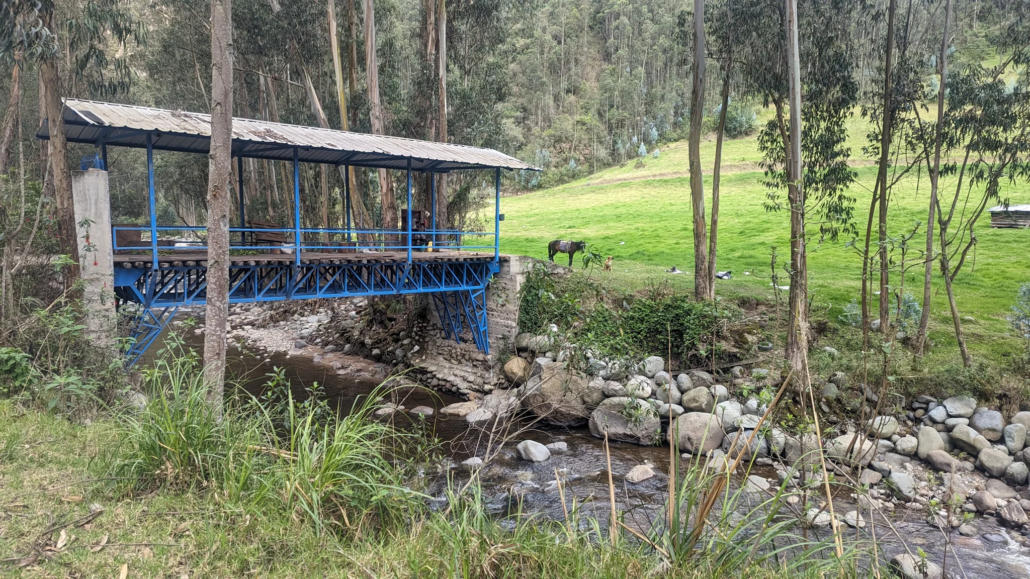 Un pequeño puente cubierto junto a una quebrada