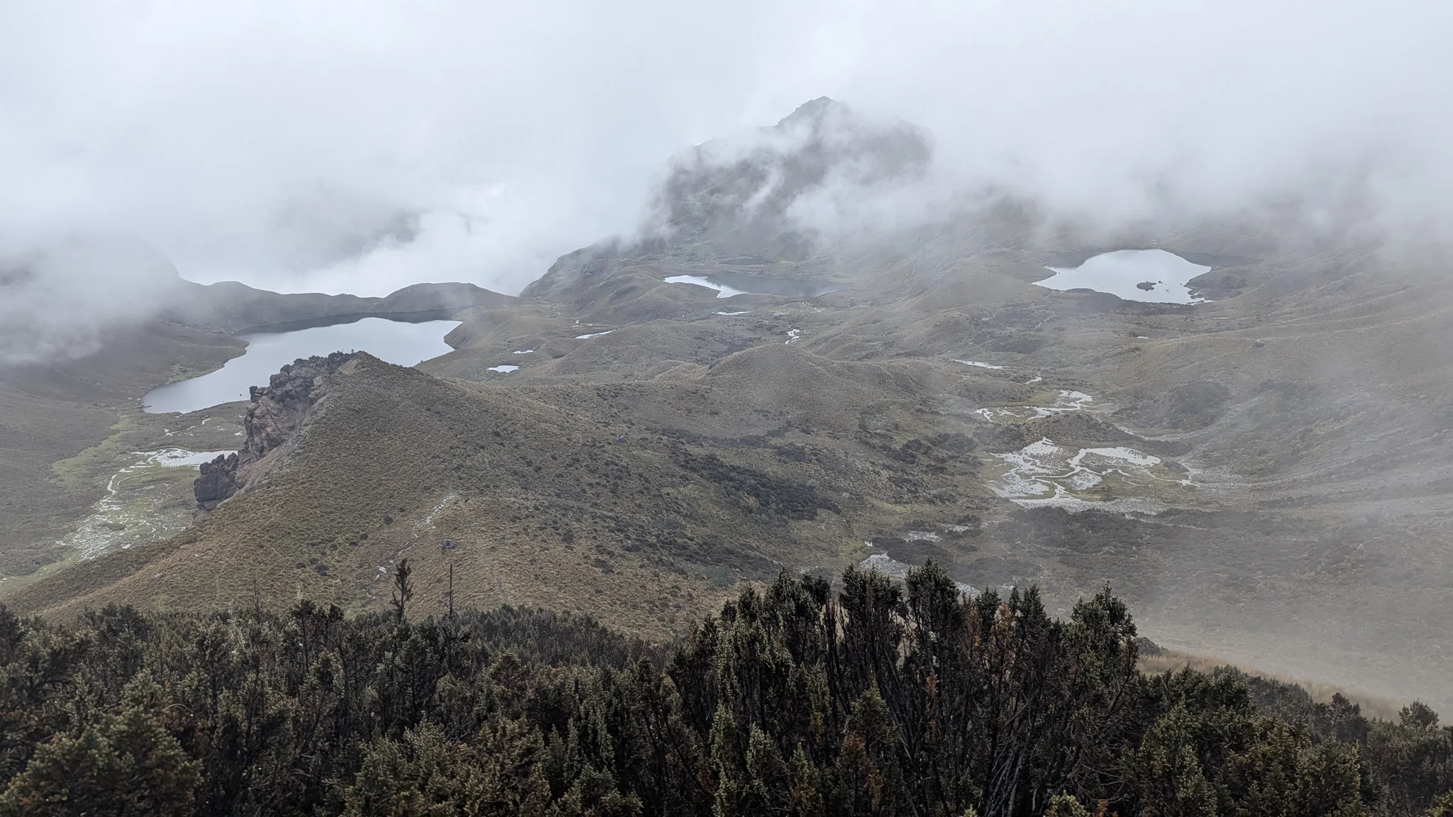 La niebla baja cruza una cuenca de altura salpicada de lagunas durante la salida de Chuzalongo. Las lagunas individuales se mantienen sin nombre.