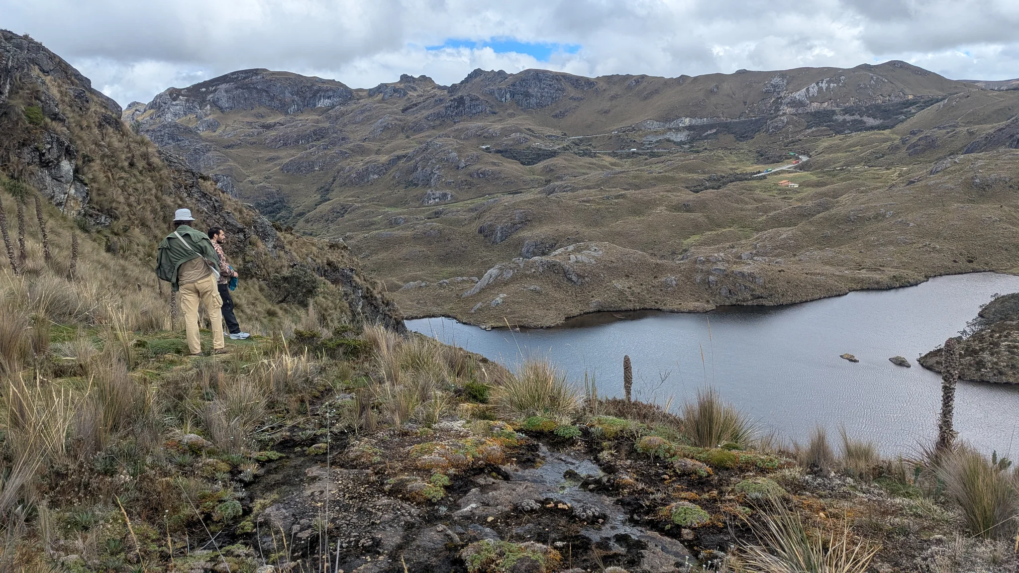 Un caminante observa una cuenca de laguna rocosa. El nombre del cuerpo de agua sigue sin confirmarse.