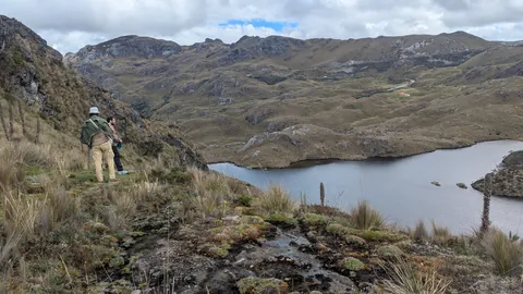 Un caminante observa una cuenca de laguna rocosa. El nombre del cuerpo de agua sigue sin confirmarse.