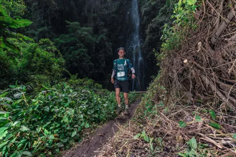 Corredor en un sendero verde y estrecho