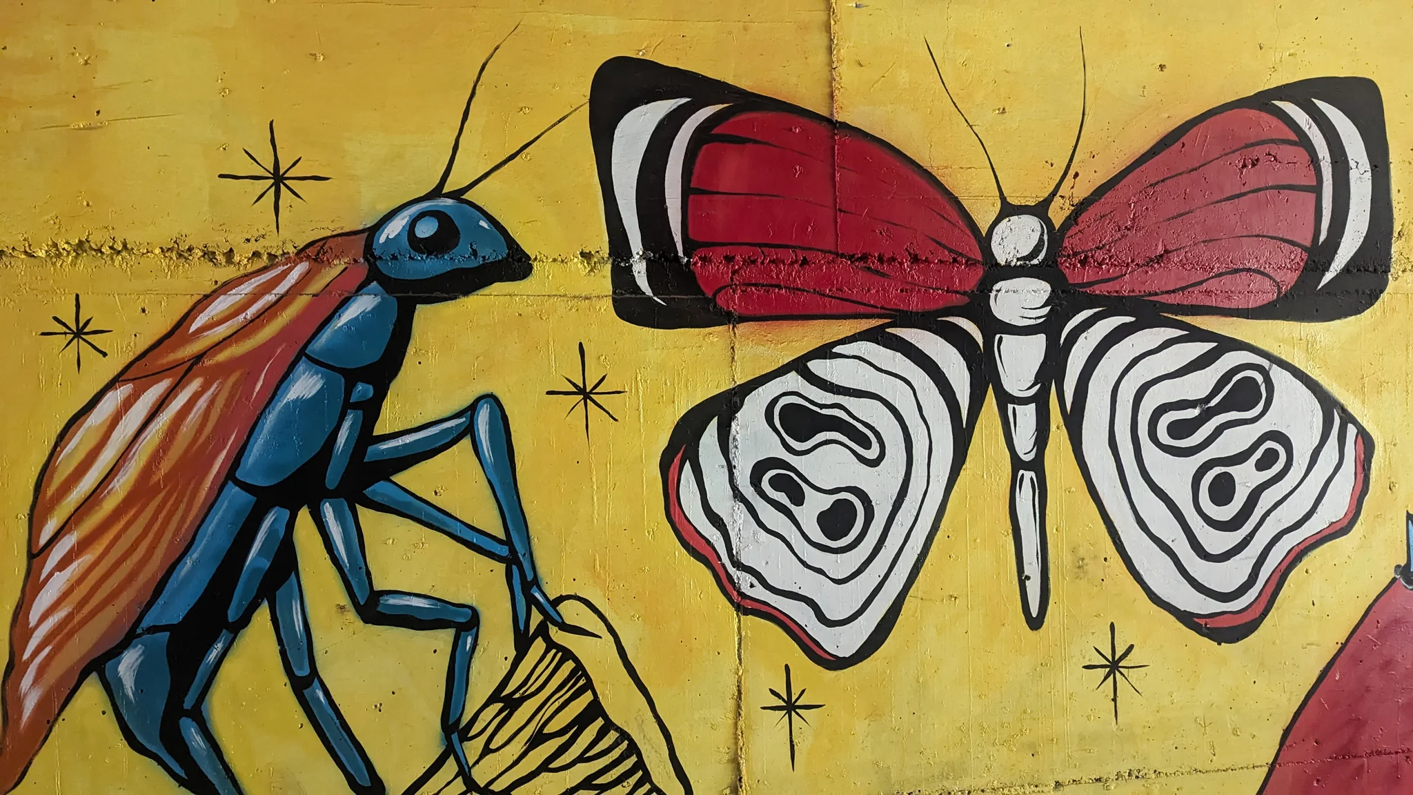 Una mariposa sobre una pared amarilla