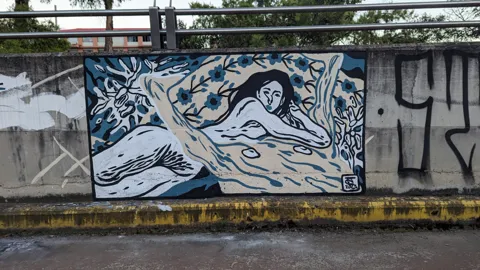 Un mural de un pez azul bajo una baranda