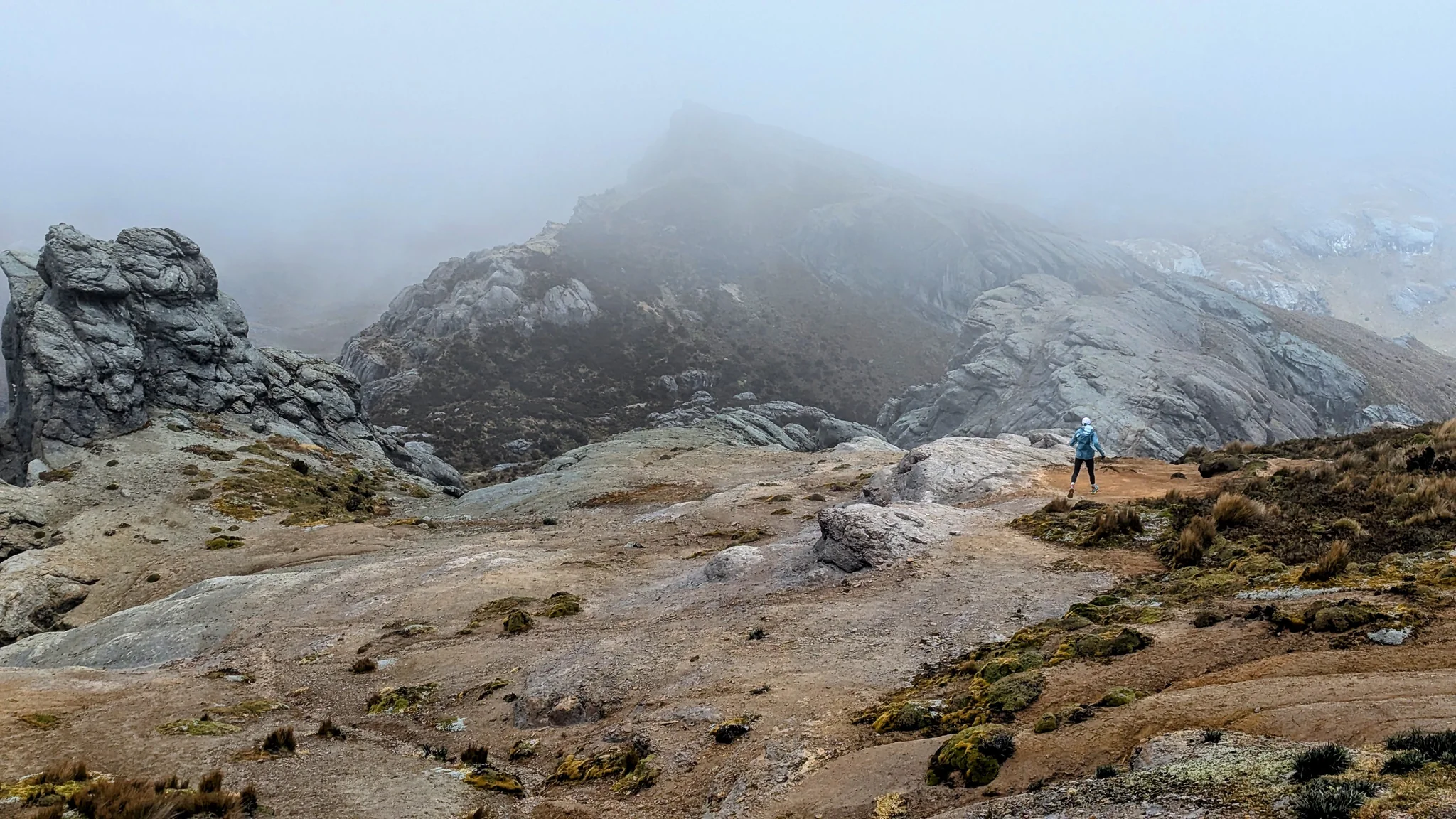 Un caminante entre losas de roca y nubes bajas
