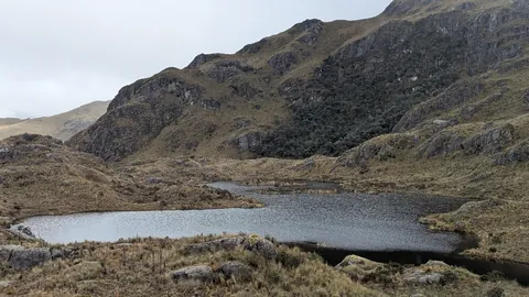 Una laguna tranquila en la parte alta del sector de Dos Chorreras se extiende bajo un filo rocoso y boscoso. Su nombre sigue sin resolverse.