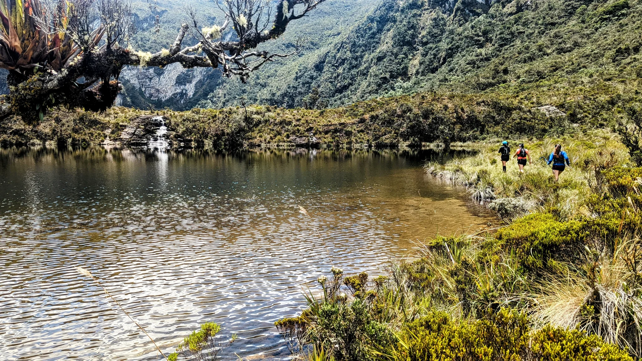 Caminantes en la orilla de una laguna. El nombre del cuerpo de agua sigue sin confirmarse.