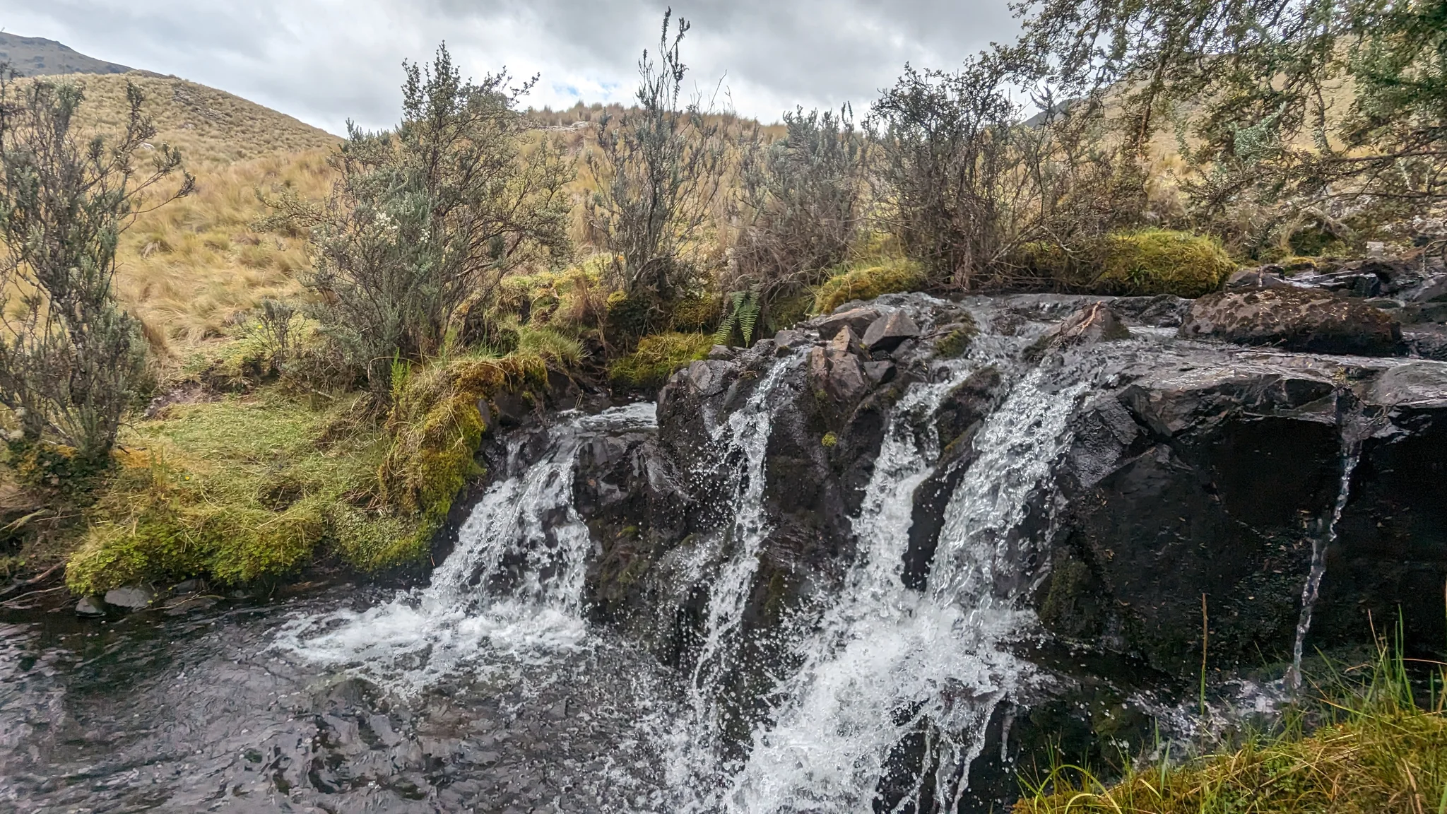 Una cascada ancha sobre roca oscura