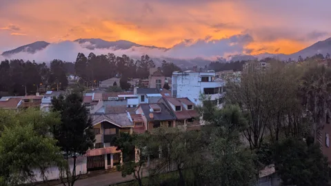 Luz anaranjada sobre casas en la ladera