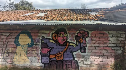 Figuras pintadas en un muro de ladrillo